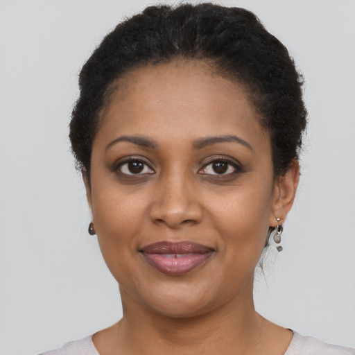 Joyful black young-adult female with short  brown hair and brown eyes