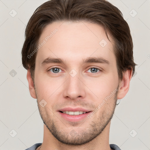 Joyful white young-adult male with short  brown hair and grey eyes