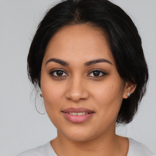 Joyful latino young-adult female with medium  brown hair and brown eyes