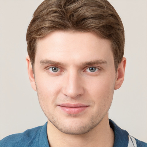 Joyful white young-adult male with short  brown hair and blue eyes