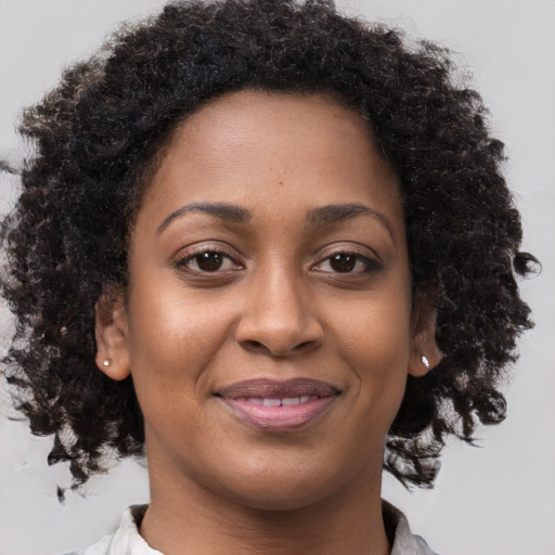 Joyful black young-adult female with medium  brown hair and brown eyes