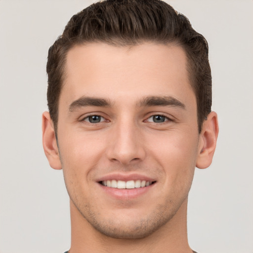 Joyful white young-adult male with short  brown hair and brown eyes