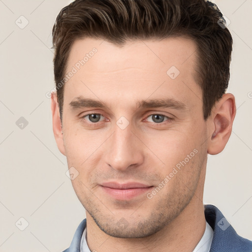 Joyful white young-adult male with short  brown hair and grey eyes