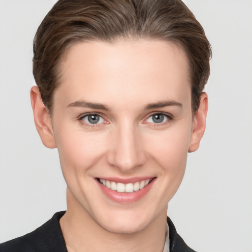 Joyful white young-adult female with short  brown hair and grey eyes