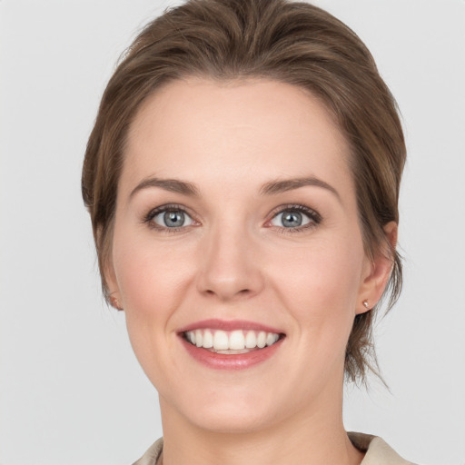 Joyful white young-adult female with medium  brown hair and grey eyes