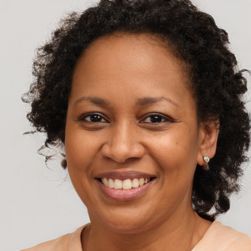Joyful black young-adult female with long  brown hair and brown eyes