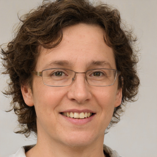 Joyful white adult female with medium  brown hair and green eyes