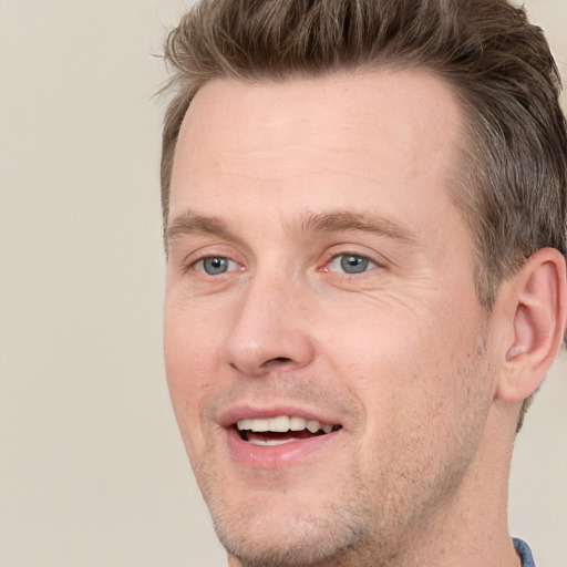 Joyful white adult male with short  brown hair and grey eyes