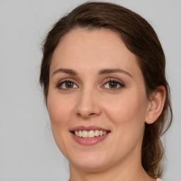 Joyful white young-adult female with medium  brown hair and green eyes