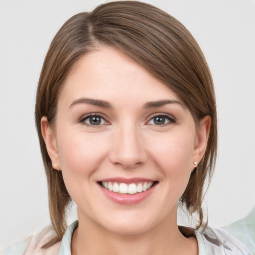 Joyful white young-adult female with medium  brown hair and grey eyes