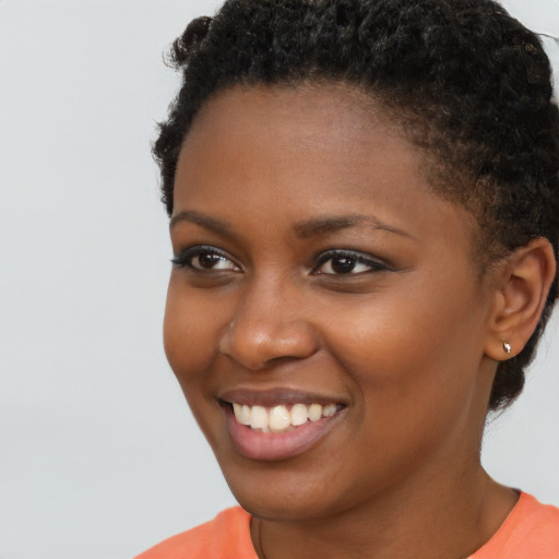 Joyful black young-adult female with short  brown hair and brown eyes