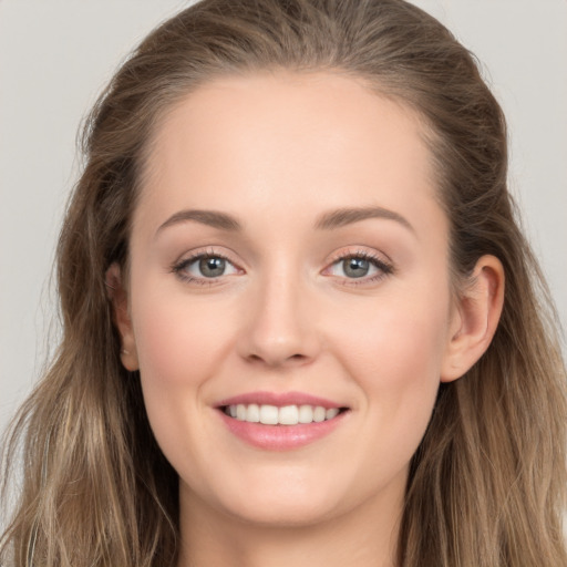 Joyful white young-adult female with long  brown hair and grey eyes