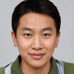 Joyful asian young-adult male with short  brown hair and brown eyes