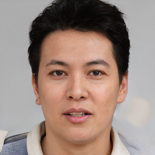 Joyful asian young-adult male with short  black hair and brown eyes