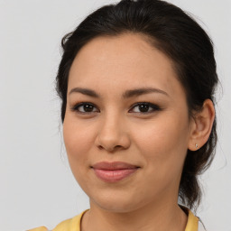 Joyful latino young-adult female with medium  brown hair and brown eyes