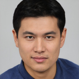 Joyful asian young-adult male with short  black hair and brown eyes