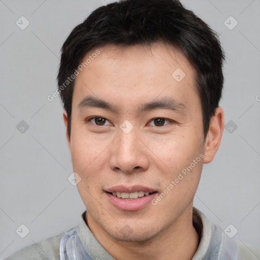 Joyful asian young-adult male with short  brown hair and brown eyes