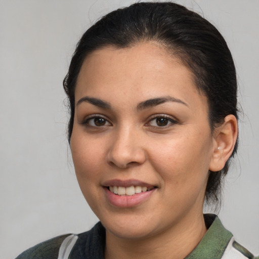 Joyful latino young-adult female with medium  brown hair and brown eyes
