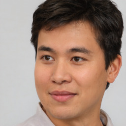 Joyful asian young-adult male with short  brown hair and brown eyes