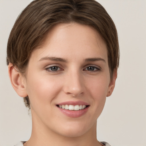 Joyful white young-adult female with short  brown hair and grey eyes