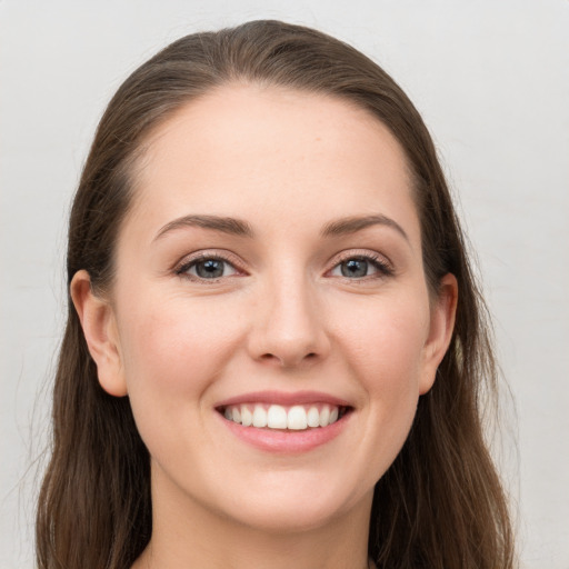 Joyful white young-adult female with long  brown hair and grey eyes