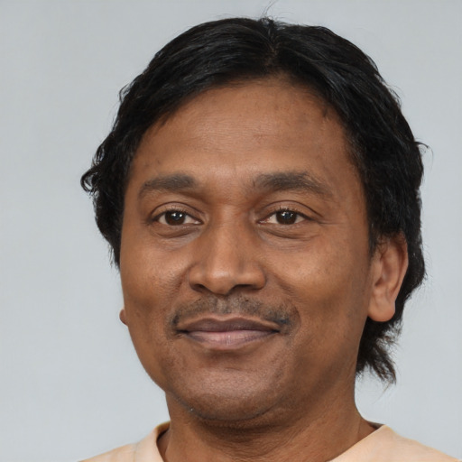 Joyful black adult male with short  black hair and brown eyes