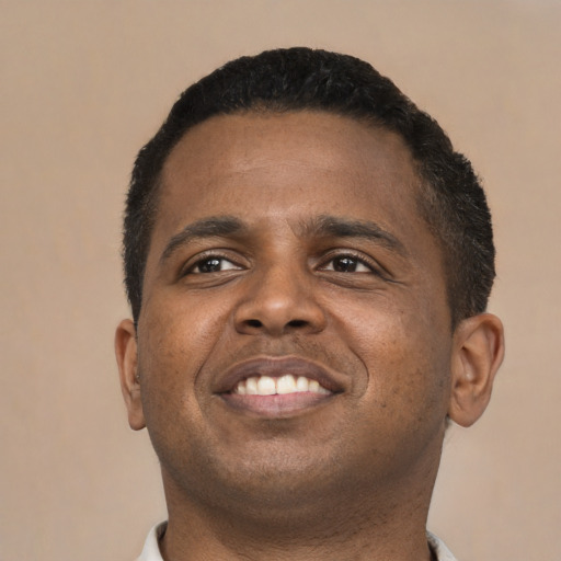 Joyful black young-adult male with short  brown hair and brown eyes