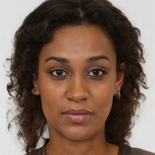 Joyful black young-adult female with medium  brown hair and brown eyes