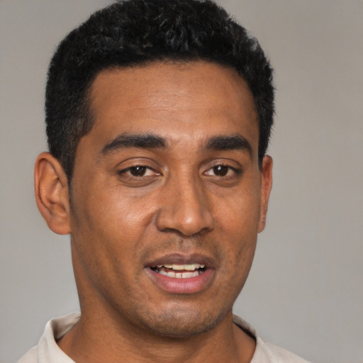 Joyful black young-adult male with short  black hair and brown eyes