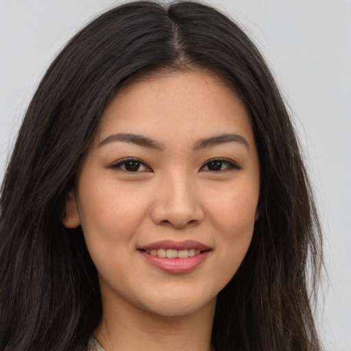 Joyful asian young-adult female with long  brown hair and brown eyes