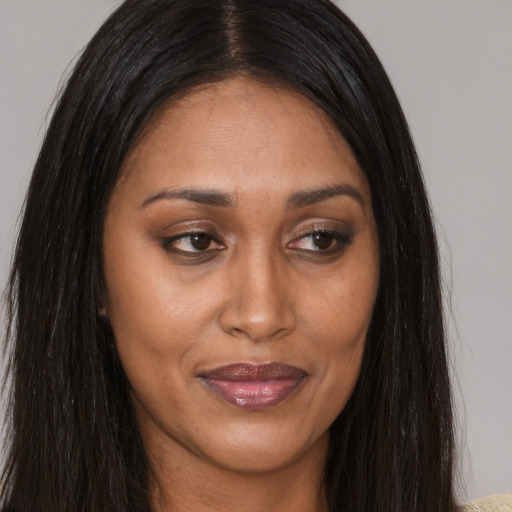 Joyful latino adult female with long  brown hair and brown eyes