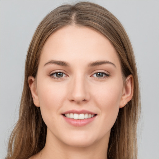 Joyful white young-adult female with long  brown hair and grey eyes