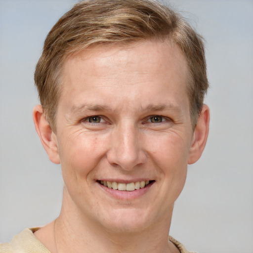 Joyful white adult male with short  brown hair and grey eyes