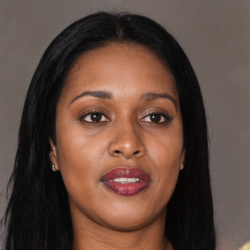 Joyful black young-adult female with long  brown hair and brown eyes