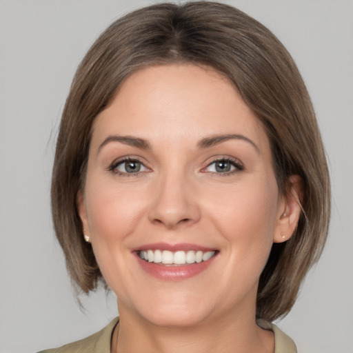 Joyful white young-adult female with medium  brown hair and grey eyes