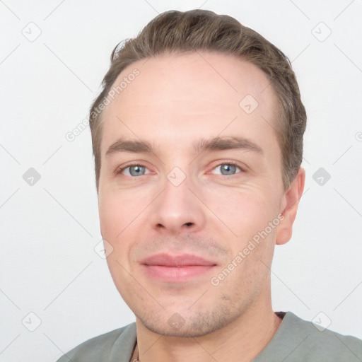 Joyful white young-adult male with short  brown hair and grey eyes