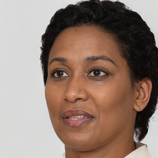 Joyful black adult female with short  black hair and brown eyes