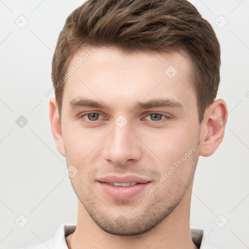 Joyful white young-adult male with short  brown hair and grey eyes