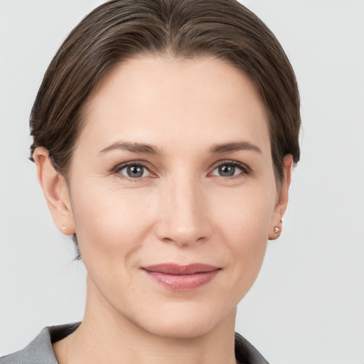 Joyful white young-adult female with short  brown hair and grey eyes