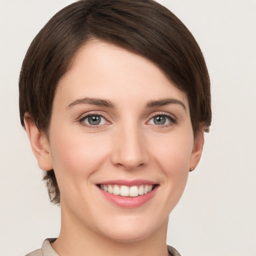 Joyful white young-adult female with short  brown hair and grey eyes