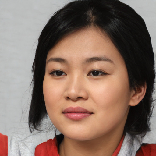 Joyful asian young-adult female with medium  black hair and brown eyes