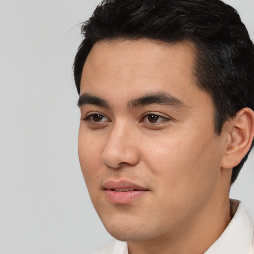 Joyful asian young-adult male with short  black hair and brown eyes