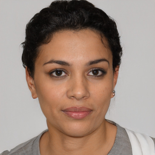 Joyful latino young-adult female with short  black hair and brown eyes