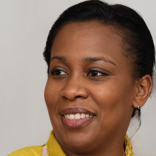 Joyful black young-adult female with medium  brown hair and brown eyes