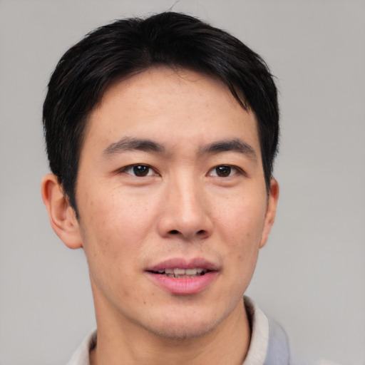 Joyful asian young-adult male with short  brown hair and brown eyes