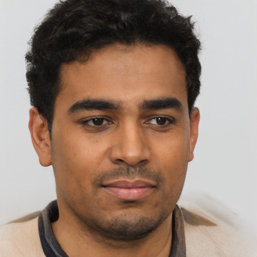 Joyful latino young-adult male with short  black hair and brown eyes