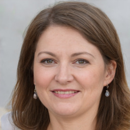 Joyful white adult female with long  brown hair and brown eyes