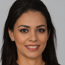 Joyful latino young-adult female with long  brown hair and brown eyes