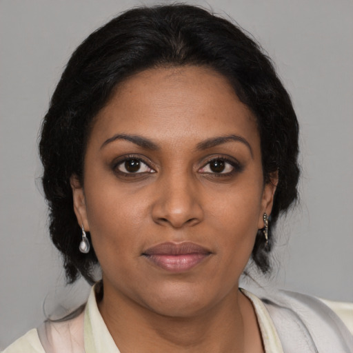 Joyful black young-adult female with medium  brown hair and brown eyes