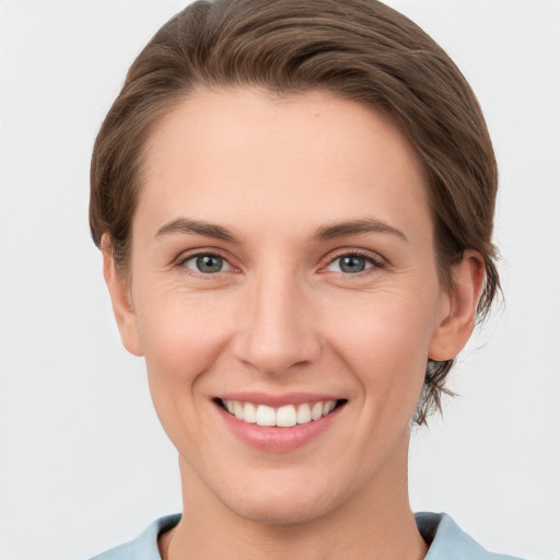 Joyful white young-adult female with short  brown hair and grey eyes